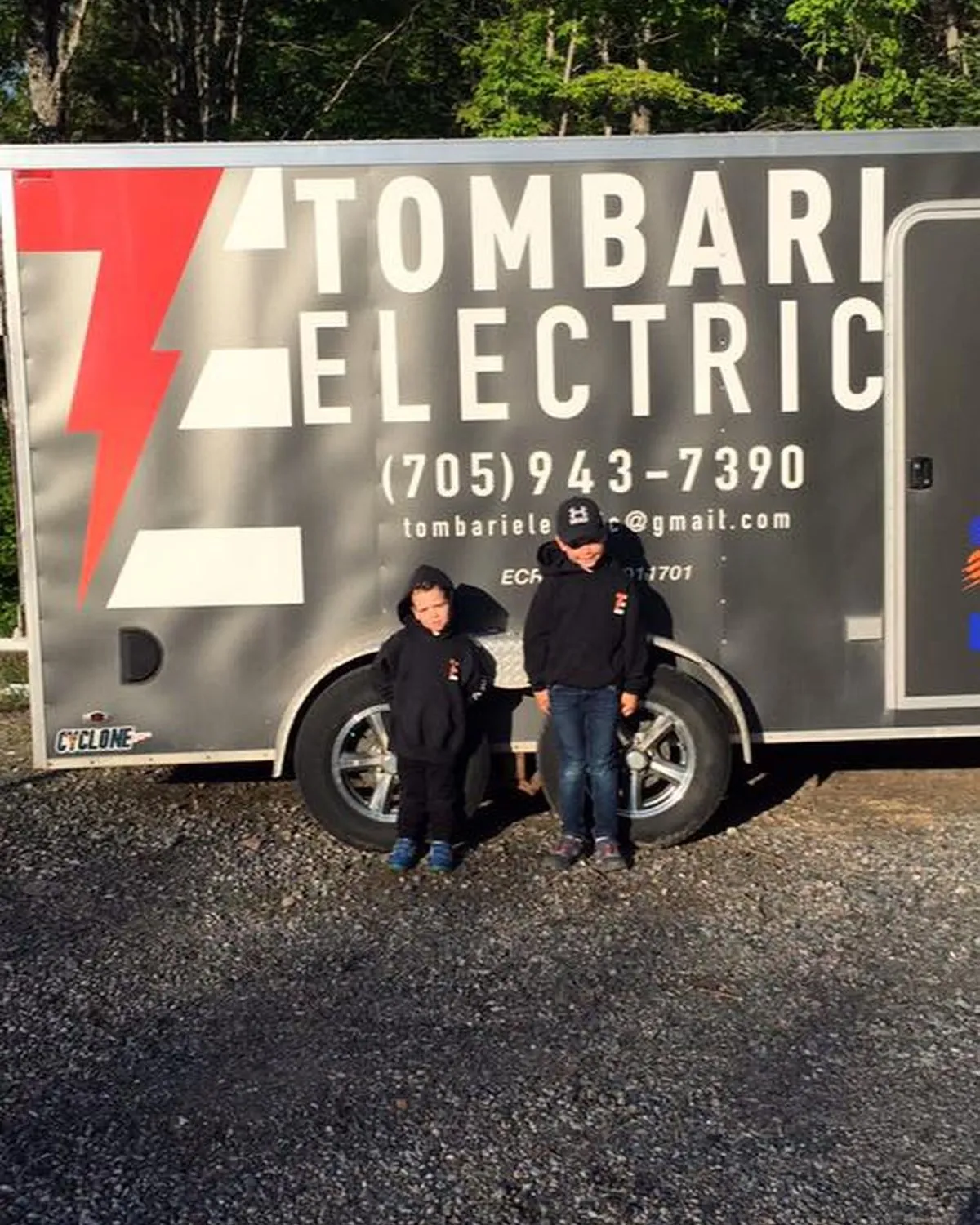 Two members of the Tombari team beside a Tombari Electric trailer