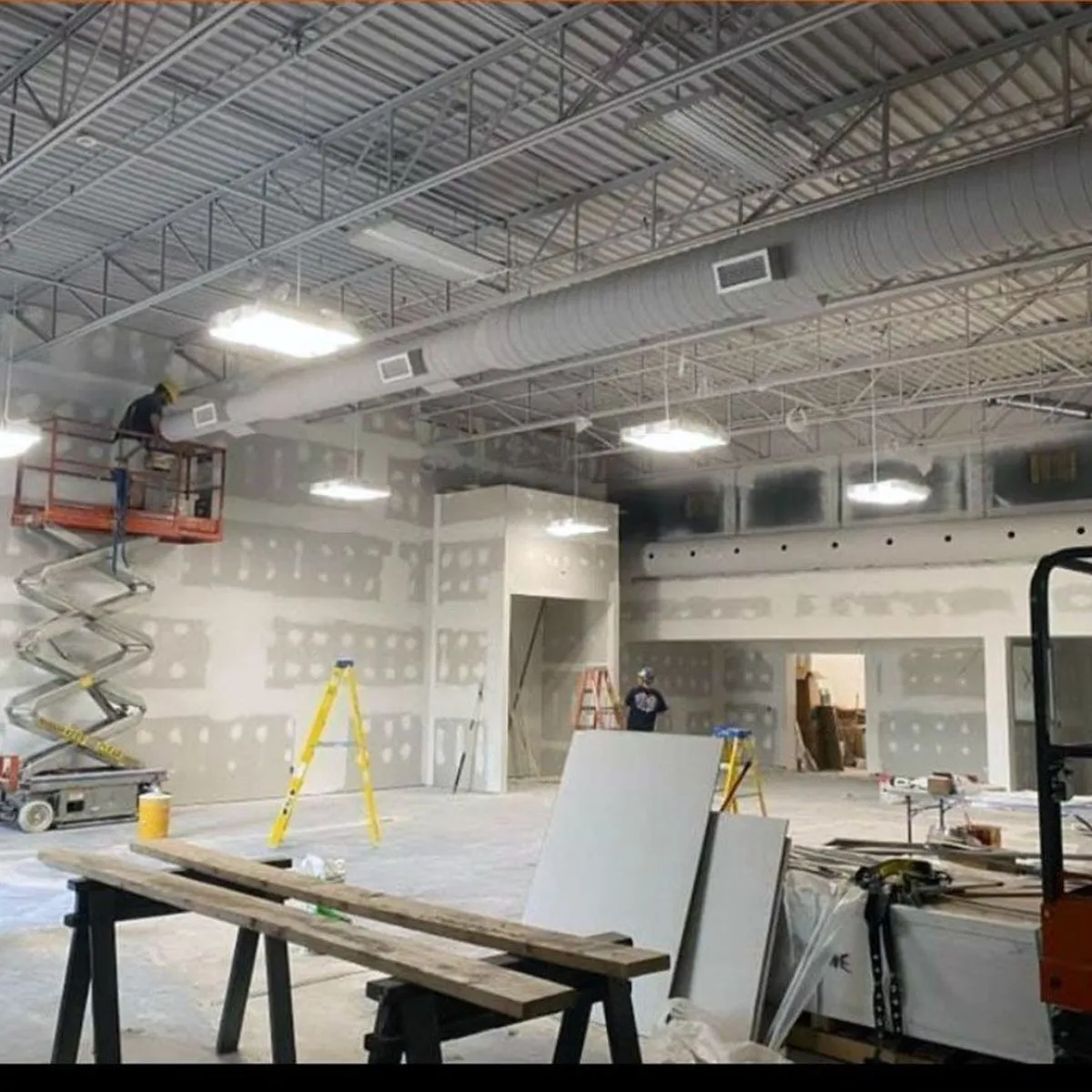 Commercial space under renovation, with a scissor lift
