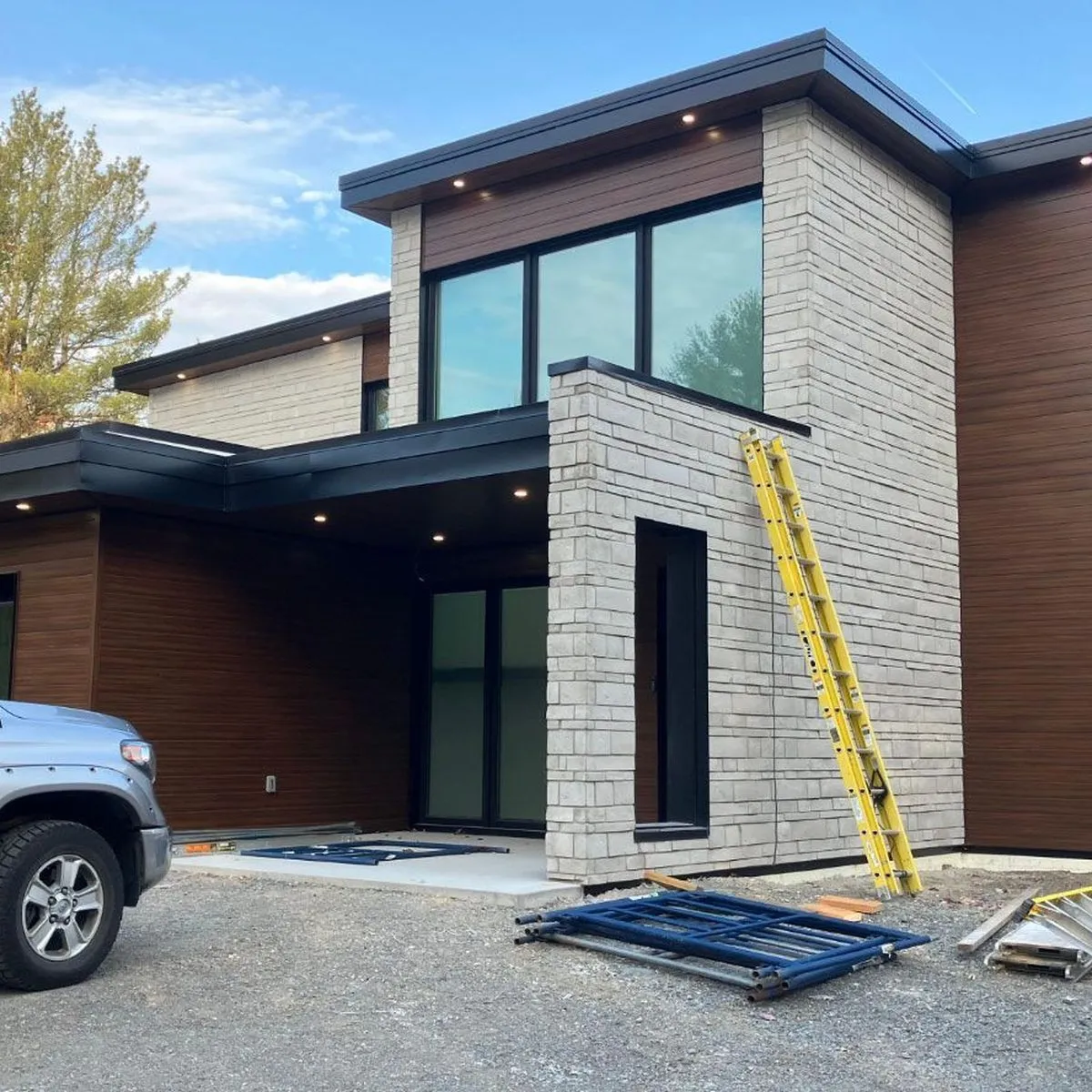 Newly built modern house with a Tombari Electric truck in the driveway